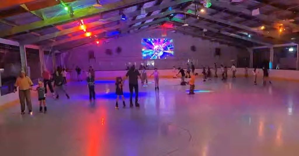People Skating on the rink under laser lights